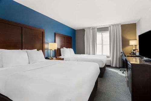 a hotel room with two beds and a television at Comfort Inn & Suites near Tinley Park Amphitheater in Tinley Park