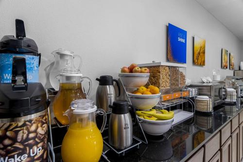 a kitchen counter with orange juice and fruit on it at Comfort Inn & Suites near Tinley Park Amphitheater in Tinley Park