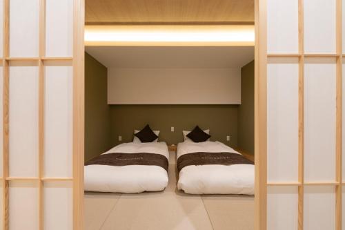 a bedroom with two beds in a room at Shirakabanoyado-KI NO NOKI, 白樺の宿-木の軒, SELF CHECK-IN in Osaka