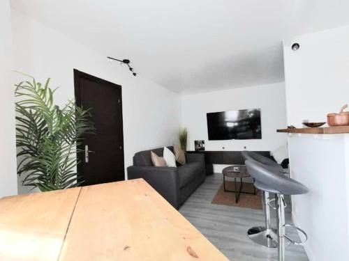 een woonkamer met een bank en een tafel bij Astérix- CDG Aéroport de Paris - Parc expos Villepinte in Louvres