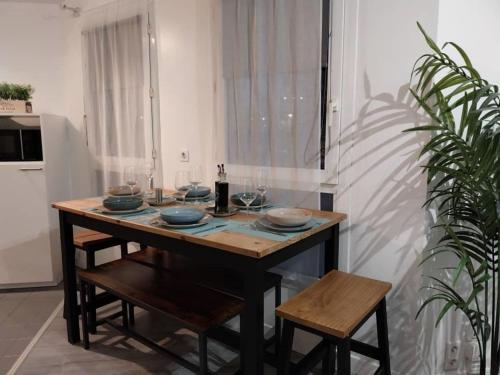 - une table avec des assiettes et des verres dans la cuisine dans l'établissement Astérix- CDG Aéroport de Paris - Parc expos Villepinte, à Louvres