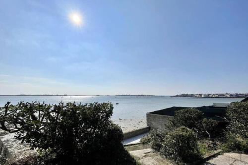 - une vue sur la plage et l'océan en arrière-plan dans l'établissement Maison de charme vue mer 180 rénovée Accès plage, à Riantec
