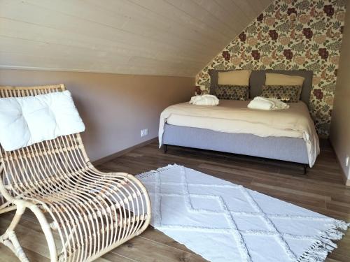 une chambre avec un lit, une chaise et un canapé dans l'établissement La maison des volcans Cantal, à Saint-Bonnet-de-Condat