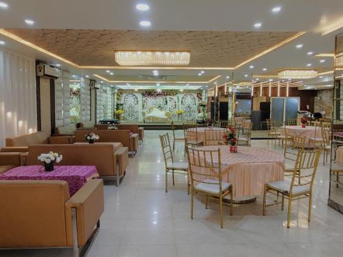 a restaurant with tables and chairs in a room at Dwelling Residency in Greater Noida