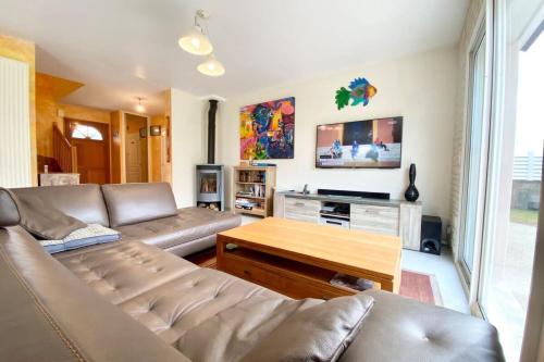un salon avec un canapé et une table dans l'établissement Jolie maison récente confort Proche des plages, à Riantec