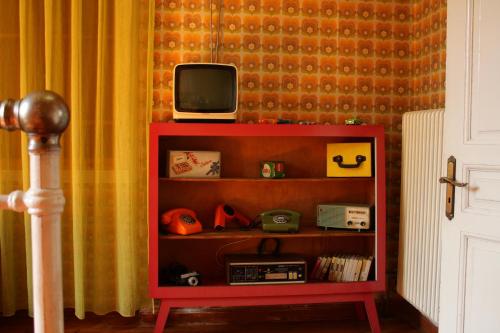 a red shelf with a tv on top of it at Kyra Vintage House in Chania