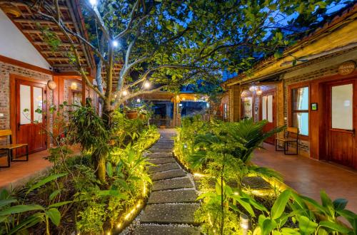 a garden with plants and lights on a building at Tam Coc Moonlight Sweet Home in Ninh Binh