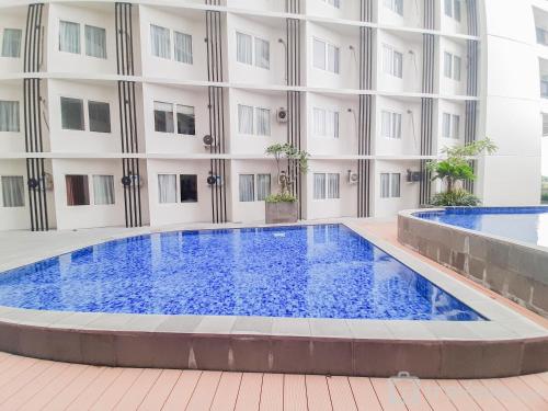 a large swimming pool in front of a building at Comfort Studio Apartment at Padina SOHO Residence By Travelio in Tangerang