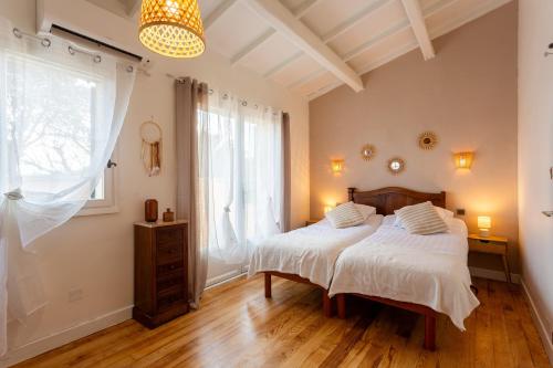 a bedroom with a bed and a large window at Le Mélomane - Maison climatisée avec jardin clos in Montfrin