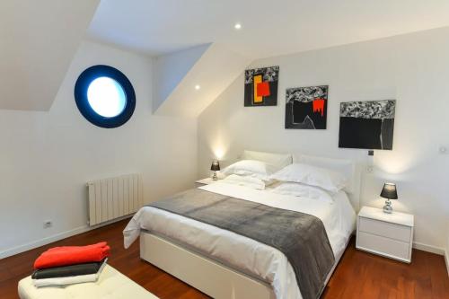 プロムールにあるLuxury Loft Vue mer exceptionnelle 180のベッドルーム1室(白い大型ベッド1台、壁に青い円)