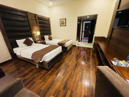 a hotel room with two beds and a couch at Legend Hotel Islamabad in Islamabad