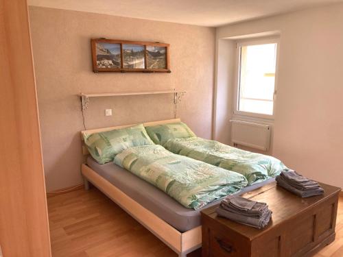 a bedroom with a bed with a table and a window at Appartamento Evelina in Airolo