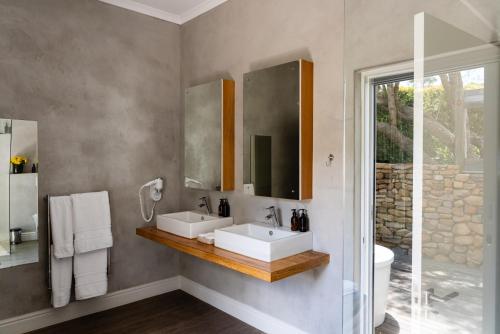 a bathroom with two sinks and a mirror at Angala in Simondium