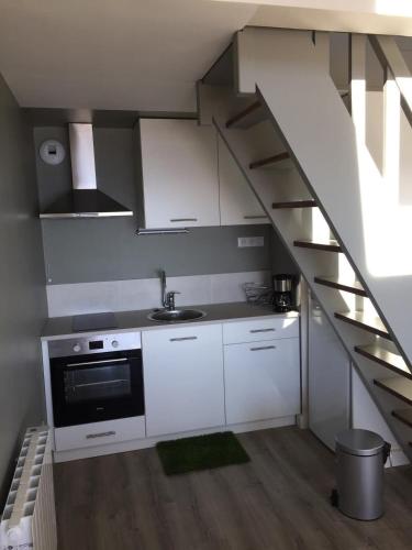 une cuisine avec des placards blancs et un escalier dans l'établissement Magnifique duplex super cosy Vue mer 180, à Ploemeur