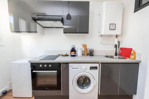 une cuisine avec une machine à laver et un évier dans l'établissement Le saint just C, à Rouen