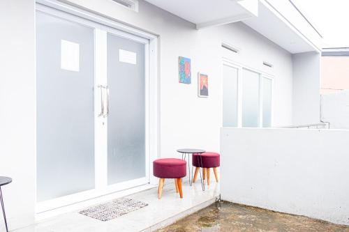 a room with two red chairs and a table at Inara Guesthouse & Villa in Padayungan