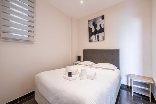 a bedroom with a white bed with towels on it at Welcoming Apartment with parking - Croisette in Cannes