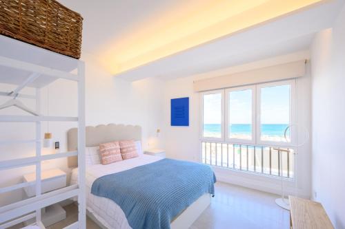a bedroom with a bed and a balcony with the ocean at La Paz by 10toSea in Fuengirola