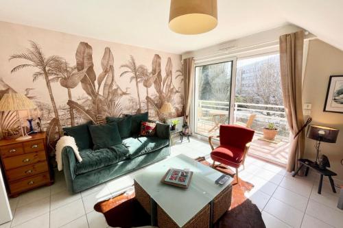 a living room with a green couch and a table at T2 Top Cosy Balcon 150m des plages in Carnac