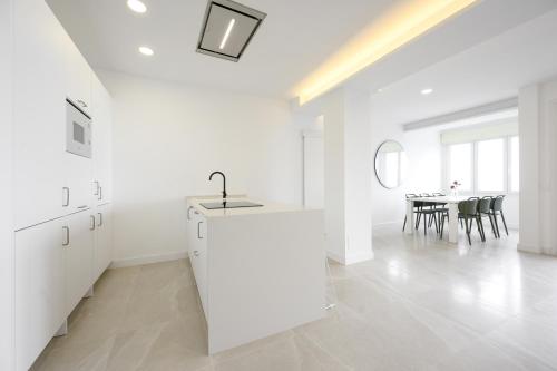 a white kitchen with a sink and a table at La Paz by 10toSea in Fuengirola