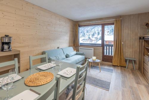 un salon avec une table et un canapé dans l'établissement Les Timalets, à Arâches-la-Frasse