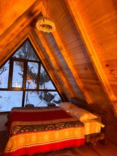 - une chambre avec un lit dans un grenier en bois dans l'établissement Villa Cottage Merisi, à Inasharidzeebi