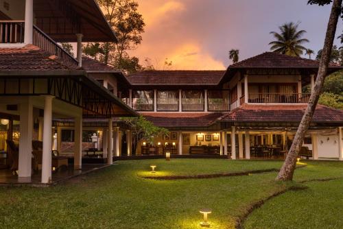 an exterior view of a villa at dusk at Cranganor History Café & Riverside Château in Parūr