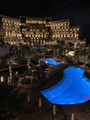a hotel with a large swimming pool at night at Apartments with three bedrooms at address hotel in Sharm