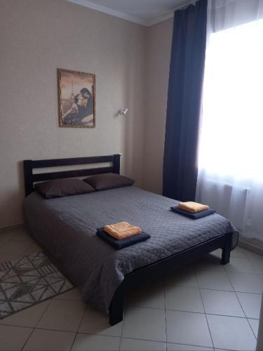 a bedroom with a bed with two towels on it at Karavella in Mykolaiv