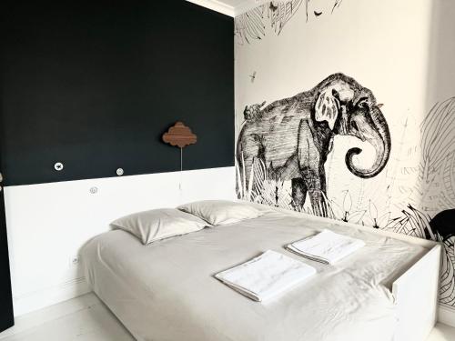 a bed with a drawing of an elephant on the wall at Family house Bordeaux centre, pool, garden, air conditioning in Bordeaux