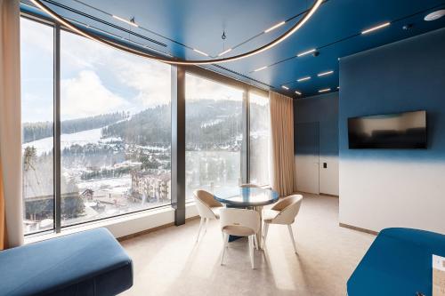 a dining room with a table and chairs and a large window at Tavel Hotel & SPA in Bukovel