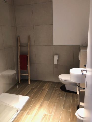 a bathroom with a toilet and a sink at Gîte Ôfé in Ouffet