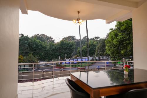 a room with a table and a balcony with a view at Athirappilly Ambady Resort in Athirappilly