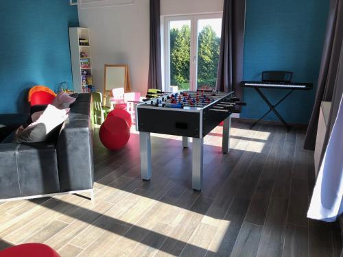 a living room with a chess table and a piano at Gîte Ôfé in Ouffet