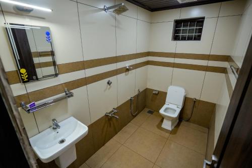 a bathroom with a toilet and a sink at Athirappilly Ambady Resort in Athirappilly