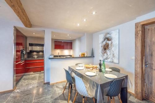 une cuisine avec une table et des chaises dans une pièce dans l'établissement Coeur de neige 1724, au Grand-Bornand