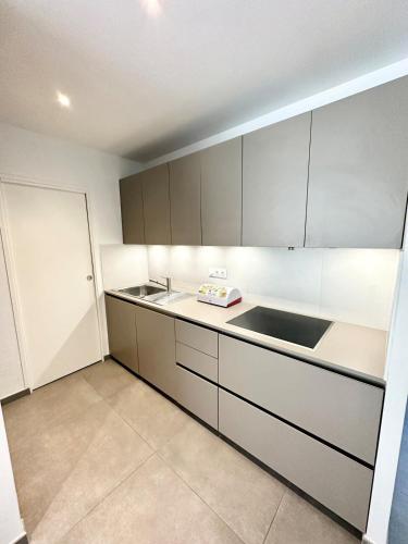 une cuisine avec des armoires blanches et un évier dans l'établissement Jolie maison récente Ultra Cosy Bord de mer, à Belz