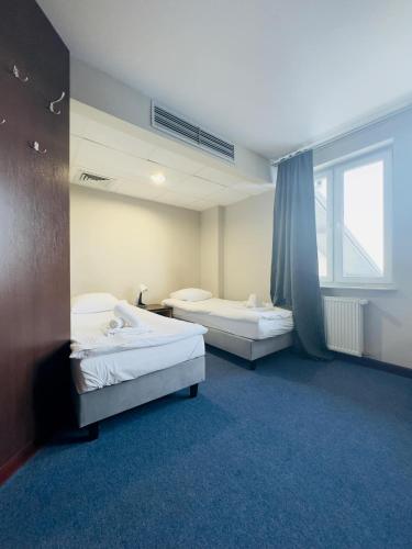 two beds in a room with a window at Magiczna Farma Hotel Obiady Mąka i Magia in Zambrów