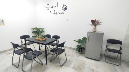a table and chairs in a room with a white wall at 33 HOMESTAY 4 Room 5 MINUTE TO LEANING TOWER in Teluk Intan