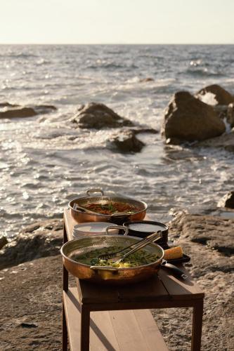 two bowls of food on a table on the beach at Maya Beach Resort in Massa Lubrense