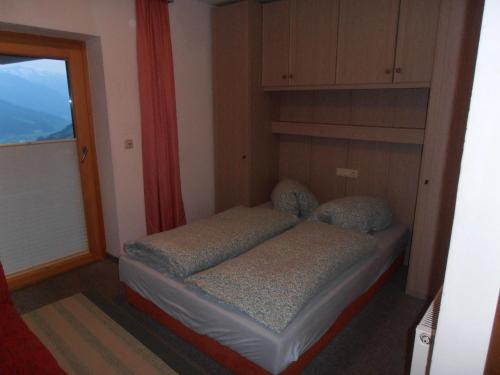 a small bed in a room with a window at Appartement Hartl in Mittersill
