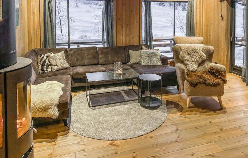 a living room with a couch and a table at Stunning Home In Flå With Sauna in Skadeland