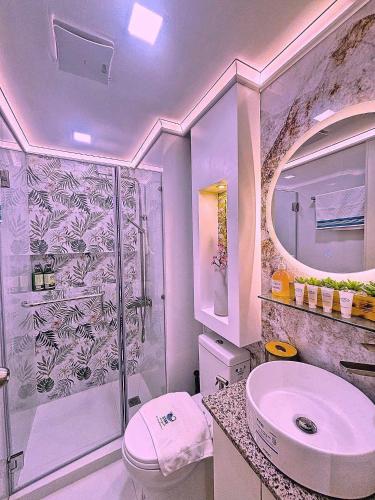 a bathroom with a toilet and a sink and a shower at Holiday Escape Philippines in Manila