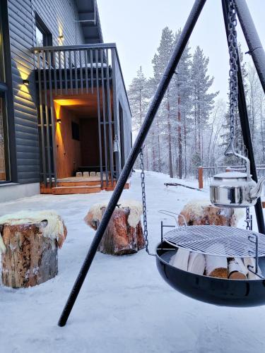 a swing in front of a house in the snow at Saana's chalets Levi in Levi