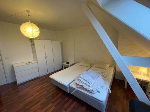 a small bedroom with a bed and a staircase at Classic Brown Stone Apartment in Copenhagen