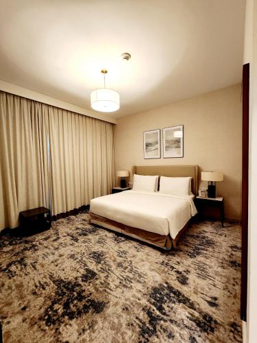 a bedroom with a large bed and two tables and two lamps at Apartments with three bedrooms at address hotel in Sharm