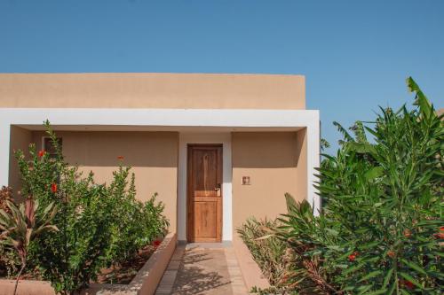a house with a door and some plants at Oasis Blu Beach Resort-Adults Only in Nungwi