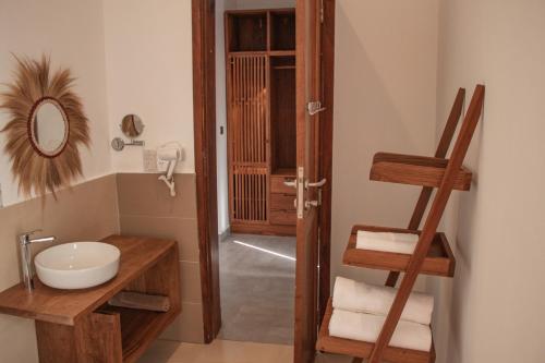 a bathroom with a sink and a mirror and a ladder at Oasis Blu Beach Resort-Adults Only in Nungwi