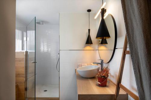 a bathroom with a sink and a glass shower at Molino de Alcuneza Relais & Châteaux in Sigüenza