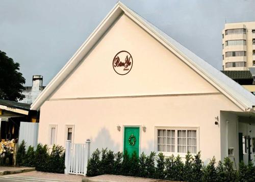 a white house with a green door at Ban Ye in Phayao